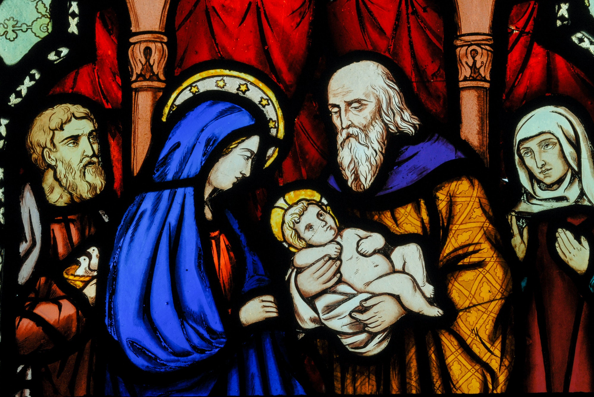 Religion and Christianity. Mary and baby Jesus depicted on stained glass window in a church